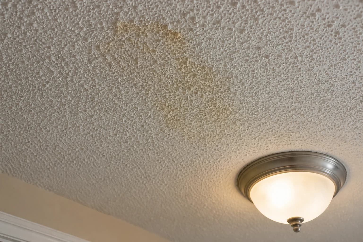 Close-up of a popcorn-textured ceiling in an older Main Line, PA home, the type of finish that typically needs asbestos testing before it's cut into or scraped